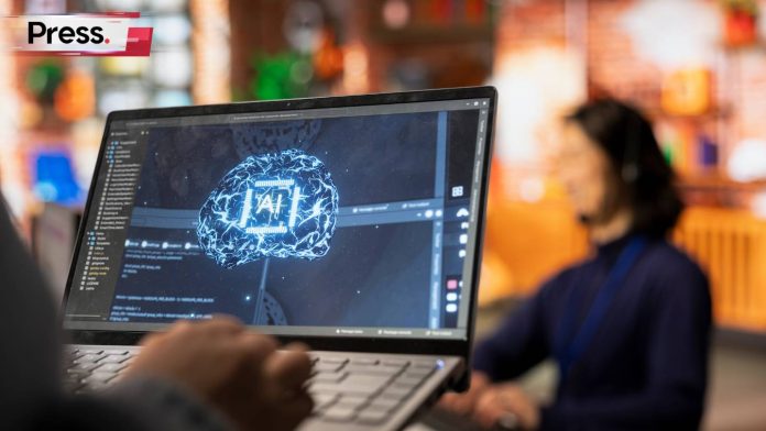 A man is seated at a workspace of some sort, with a laptop in his lap and another person working in the background. On the laptop screen is a brain symbol and the word 'AI', as he generates a logo for his content on SEO ranking.