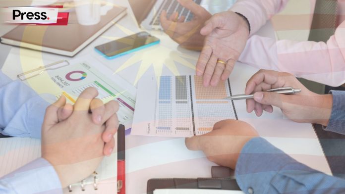 Malaysian business team reviewing e-invoicing, SST, and ESG compliance data during Budget 2026 planning.