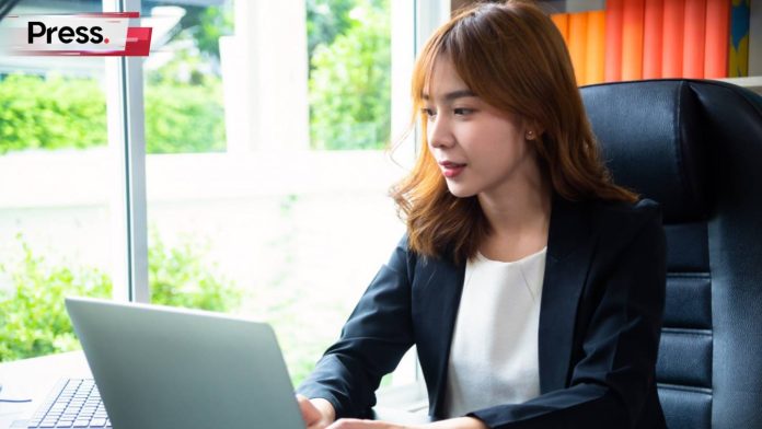 A businesswoman sits at her desk staring at her laptop. It's a sunny day outside, but she seems to be deep in concentration as she studies the laptop screen and learns how to use Microsoft Copilot to boost her SEO.