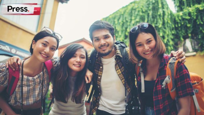 A racially diverse group of Malaysian friends, three women and one man, smile for the camera as they stand in front of a building. Catering to the diversity of cultures in Malaysia requires multilingual SEO.