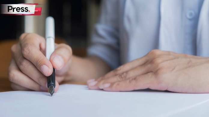 Malaysian man writing his will on a piece of paper