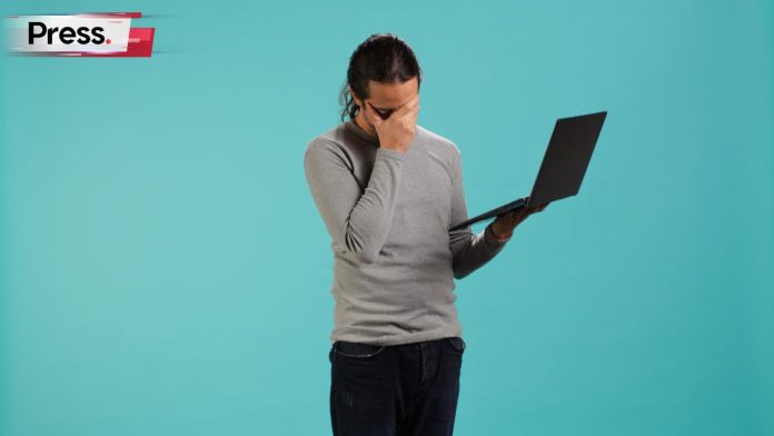 A sad man covers his face with his hand, while holding a laptop in the other hand. He is frustrated over the 10 top SEO Malaysia mistakes that companies often make.