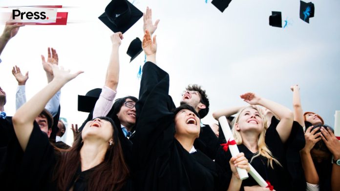 A group of graduate students throwing their caps into the air, celebrating after finishing their postgraduate studies.