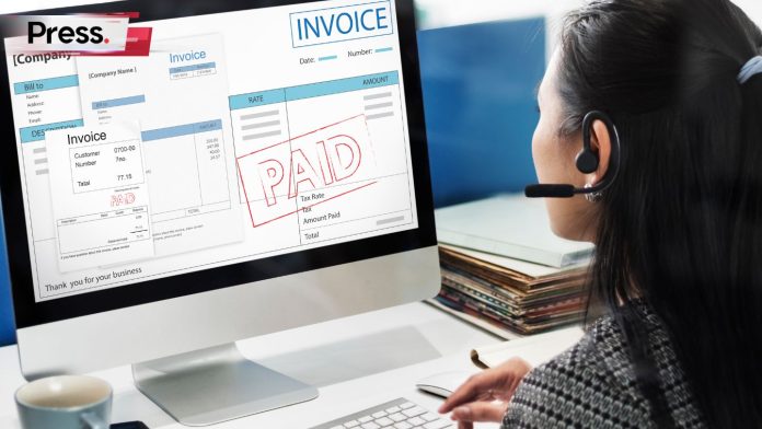 A women with headphone microphone looking at computer screen with invoice listed 