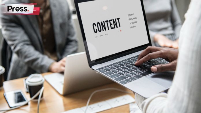 A businessman using his laptop in a meeting at a content marketing agency. On his laptop, you can see the word 'content' in large black letters, with smaller text next to it describing its purpose.