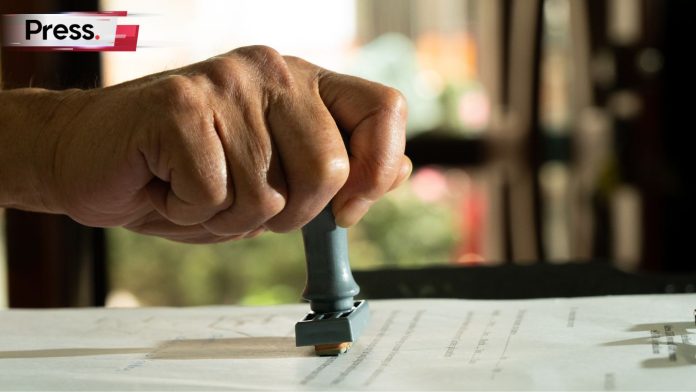 Person signing approval document certificate legal agreement in office by pen and stamp