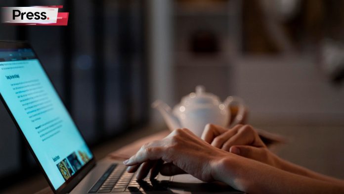 A person types on their laptop, performing SEO copywriting