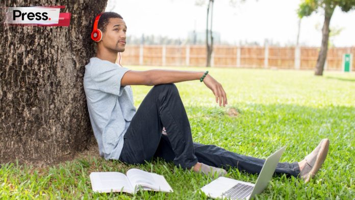 A student relaxes while listening to music on his gap year.
