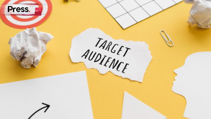 A table with scraps of paper on it. The scrap in the middle of the table reads 'target audience'.