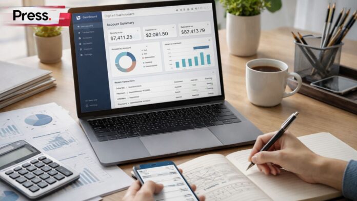Photo image showing a person taking notes in a journal while viewing a financial dashboard on a laptop and holding a smartphone.