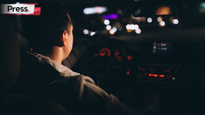 Photo of a fresh graduate driving his car at night