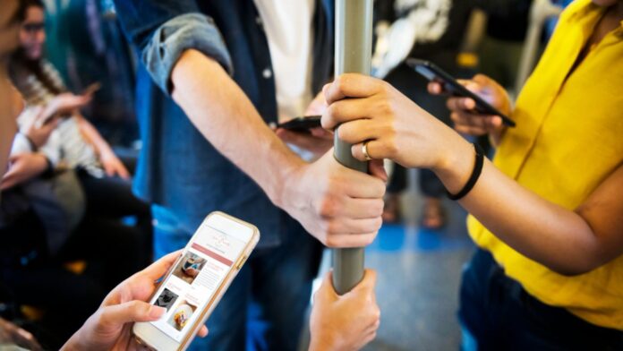 A group of friends on their cellphones in the train, representing mass communication courses