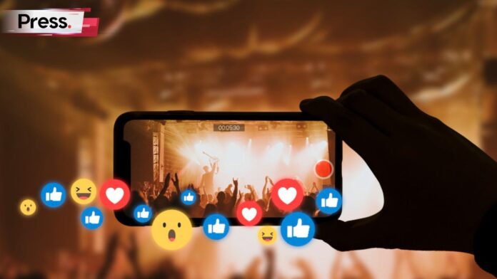 Photo of a phone screen at a concert with emoticons coming out of it, representing something going viral