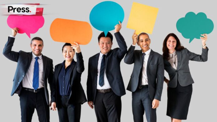 Photo of PR employees holding up cutouts of speech bubbles, representing public relations jobs