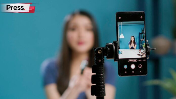 Photo of an influencer in front of the camera, representing the idea of human influencers vs virtual influencers
