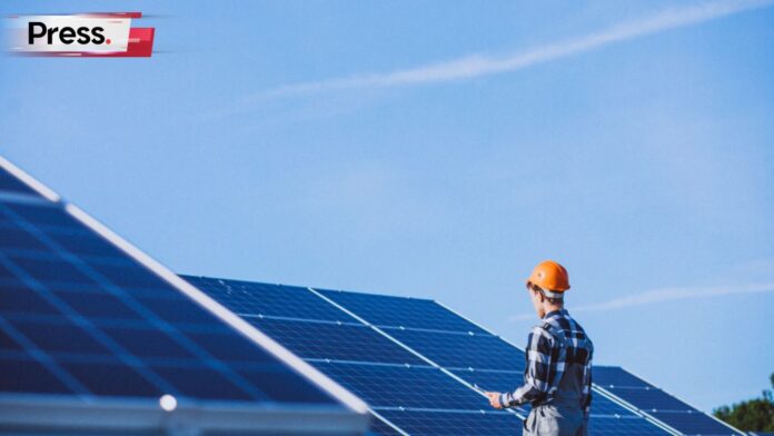 Photo of a construction worker standing in front of solar panels