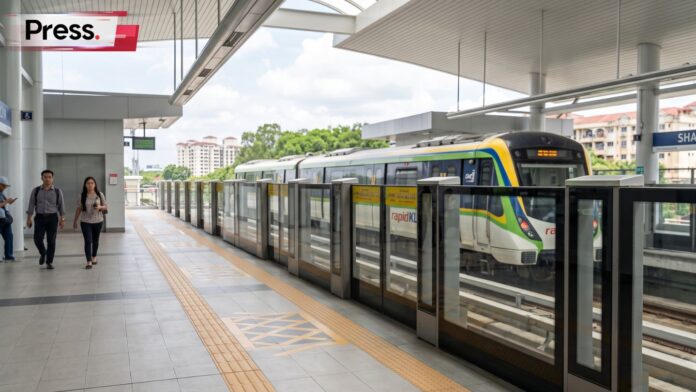Modern RapidKL LRT3 train at the Shah Alam station platform with commuters walking in the background.